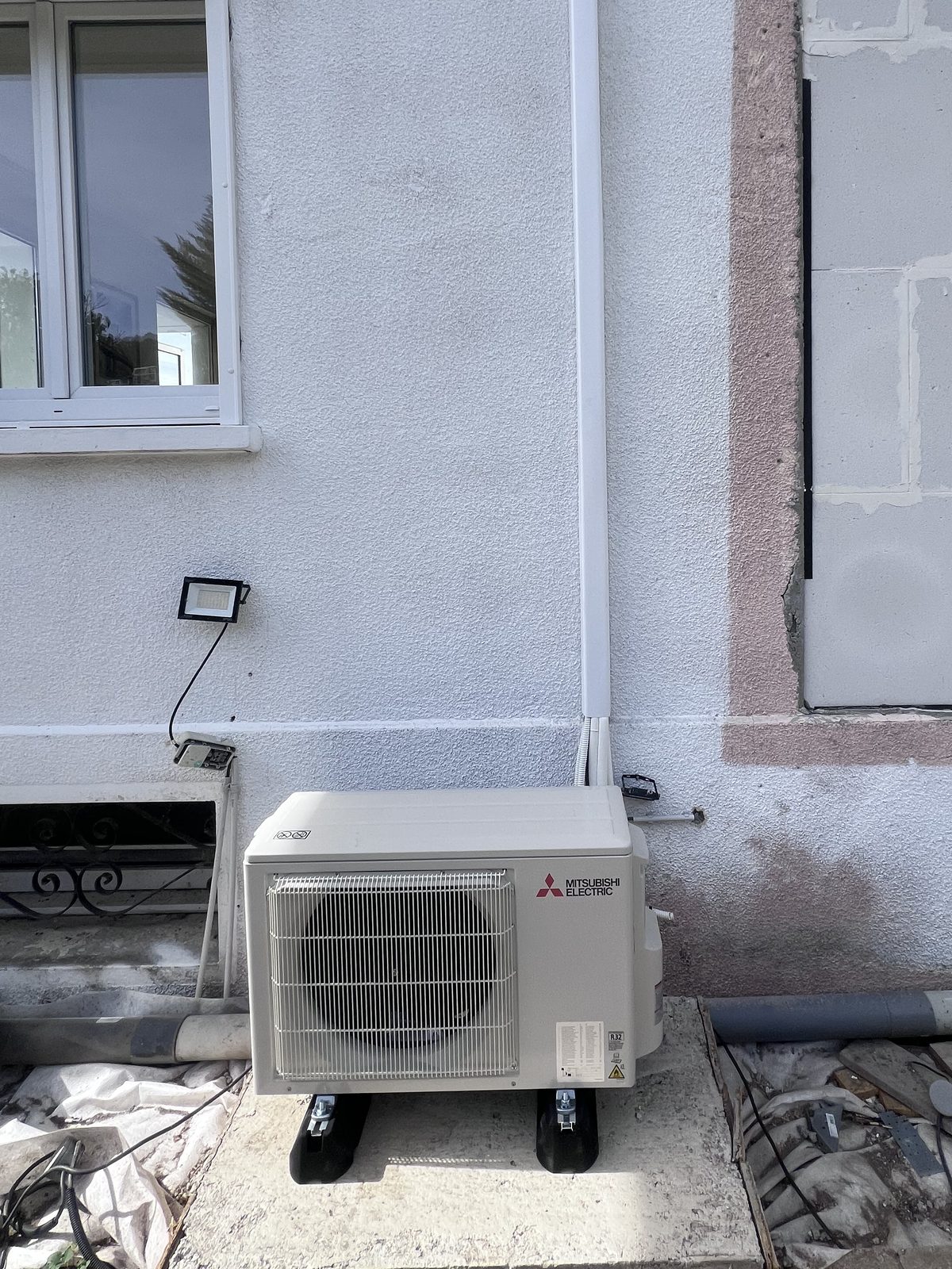 Groupe extérieur Mitsubishi Electric posé au sol sur supports anti-vibratiles